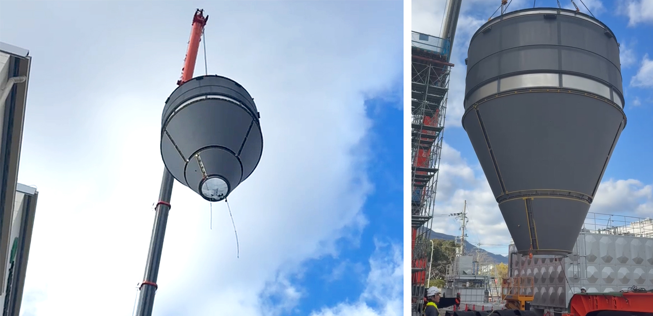 大型クレーンで機械を慎重につり下げている